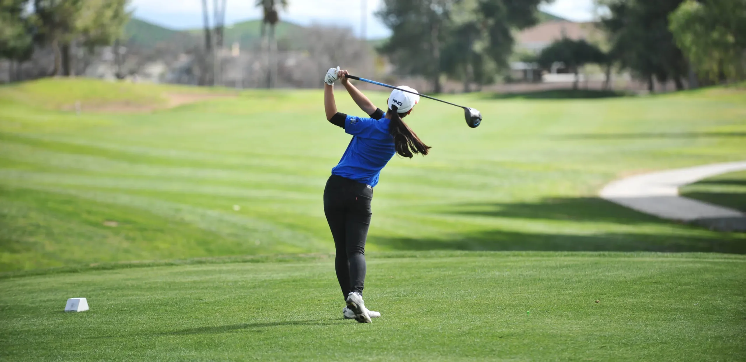 Junior golfer in follow-through on the college pathway